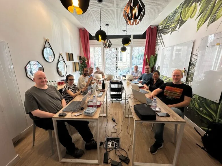 Group photo of Mellonne's team gathered around a conference table during a team meeting