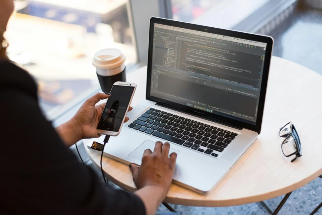 Laptop and phone connected through usb, it represent Mellonne's experties in app development